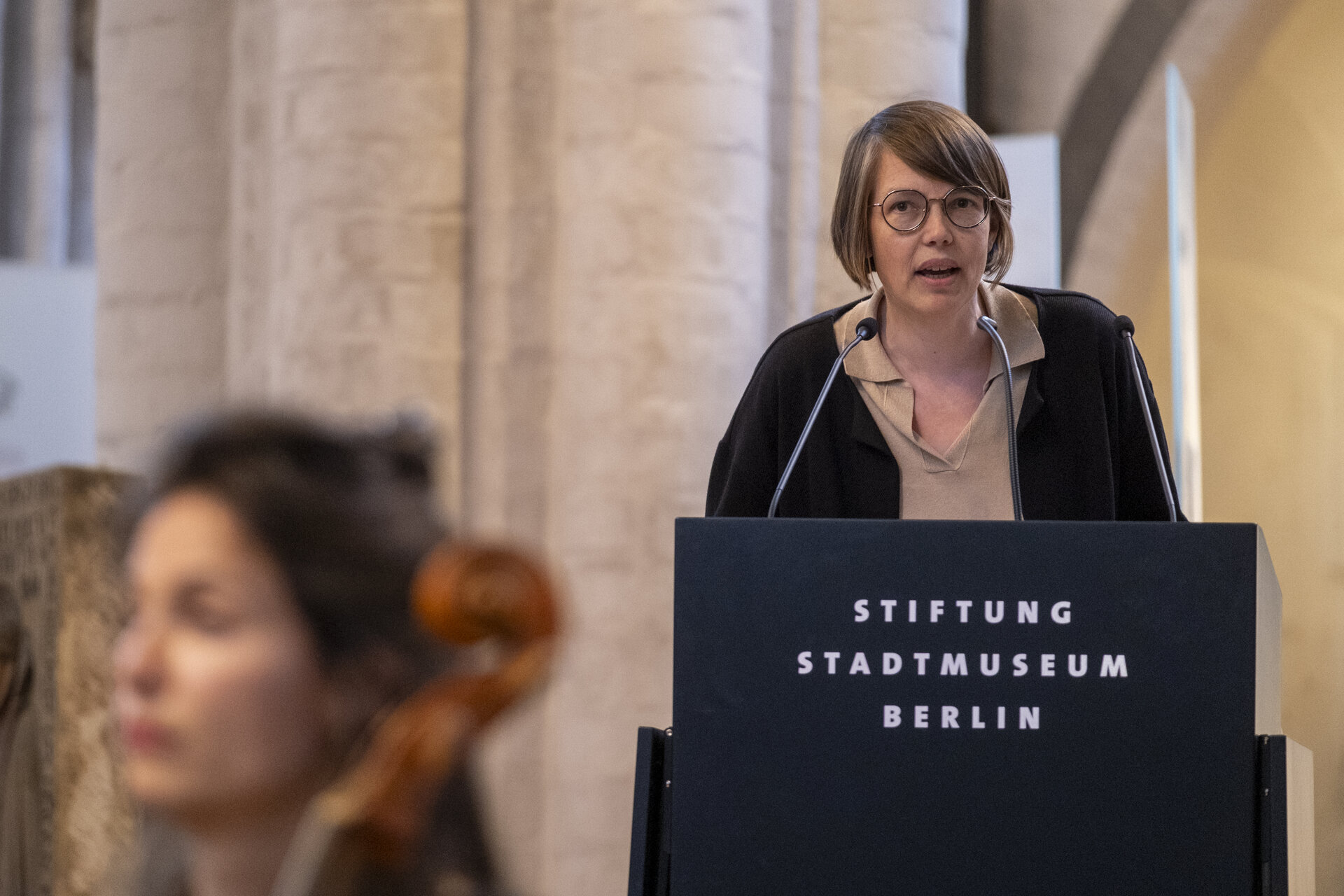 Eine Frau an einem Sprechpult.