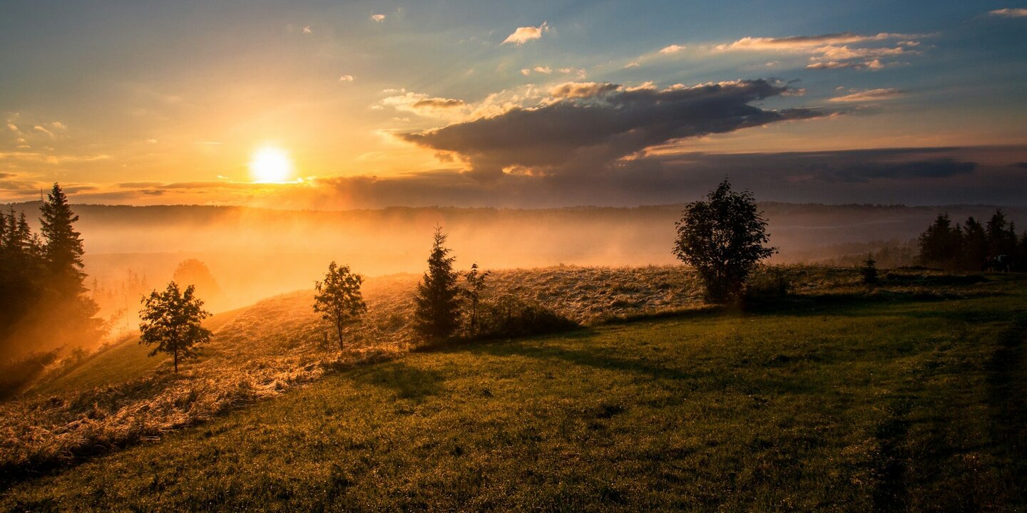 Sonnenaufgang Die Sonne geht über einem nebligen Tal auf.
