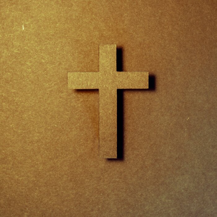 An einer goldenen Wand hängt ein goldenes Kreuz