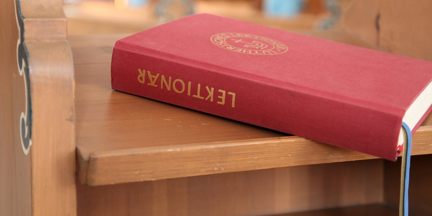 rotes Buch liegt auf einer Holzbank