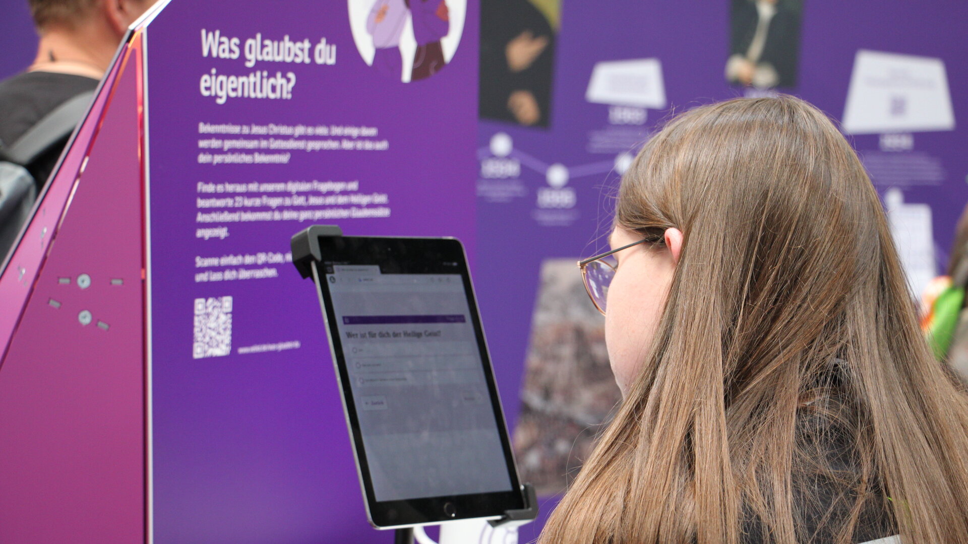 Eine Frau sitzt sieht auf ein Tablet.