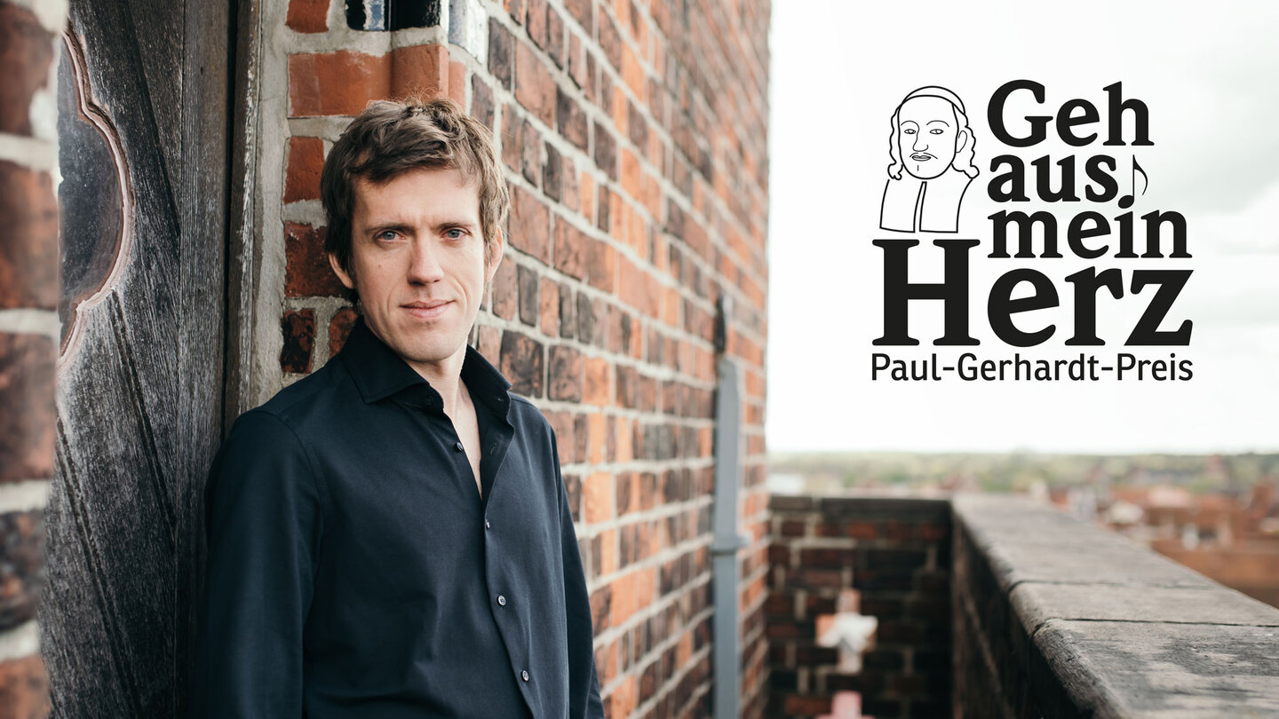 Ein Mann in schwarzem Hemd steht auf einem Kirchturm